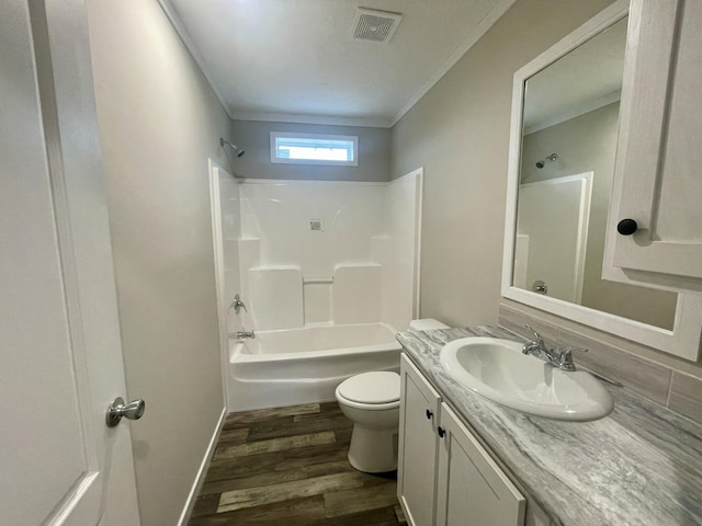 full bathroom with hardwood / wood-style floors, ornamental molding, vanity, toilet, and bathing tub / shower combination