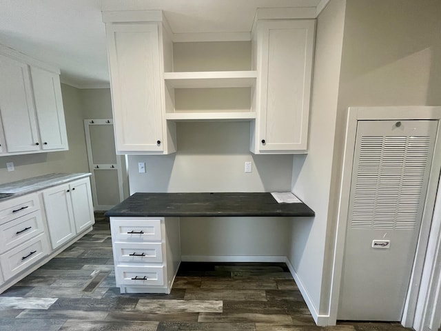 kitchen with white cabinetry, built in desk, and dark hardwood / wood-style flooring
