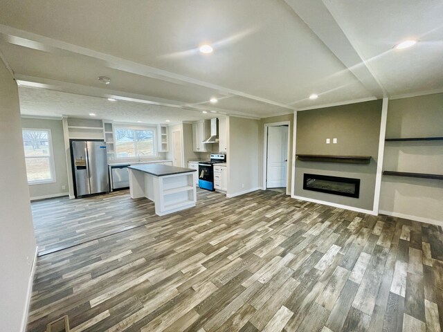 kitchen featuring white cabinetry, appliances with stainless steel finishes, a center island, and light wood-type flooring