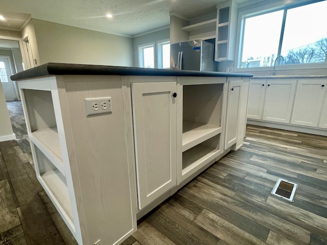 interior details featuring stainless steel refrigerator, sink, hardwood / wood-style floors, and crown molding