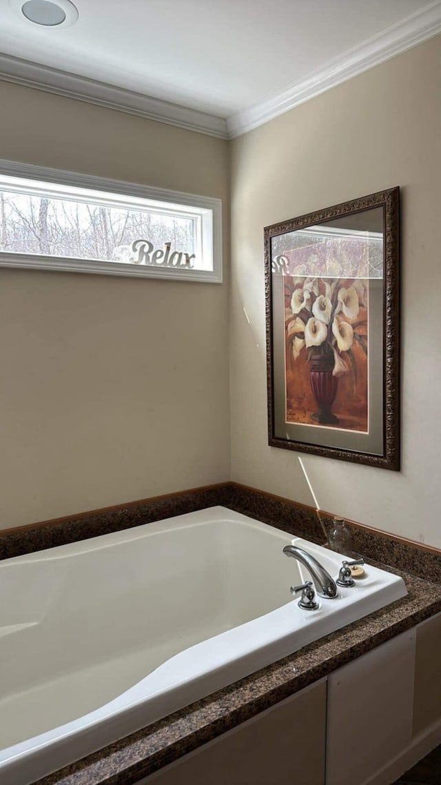 bathroom with crown molding and a bath