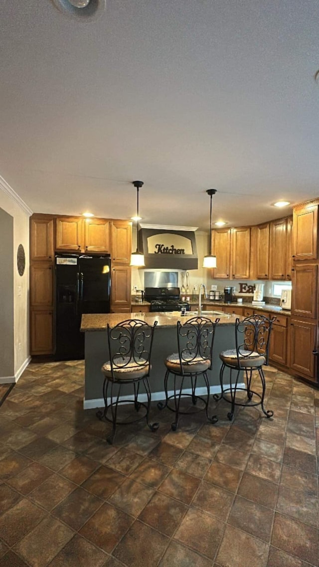 kitchen with pendant lighting, crown molding, a breakfast bar, a kitchen island with sink, and black refrigerator with ice dispenser