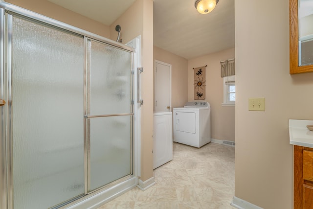 bathroom featuring washer / dryer, vanity, and a shower with shower door