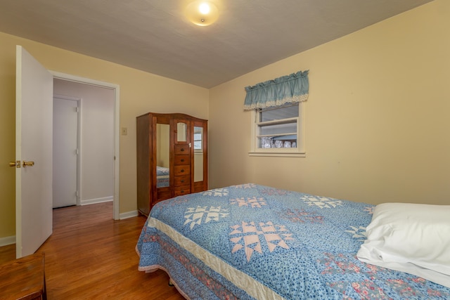 bedroom featuring wood-type flooring and vaulted ceiling