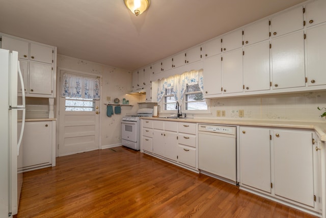 kitchen featuring white cabinets, white appliances, sink, and light hardwood / wood-style flooring