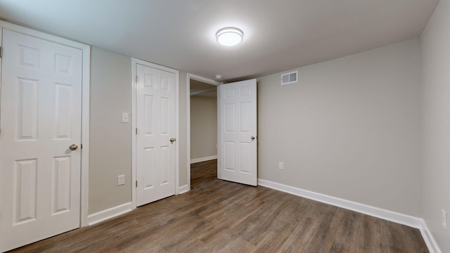 unfurnished bedroom with dark hardwood / wood-style flooring