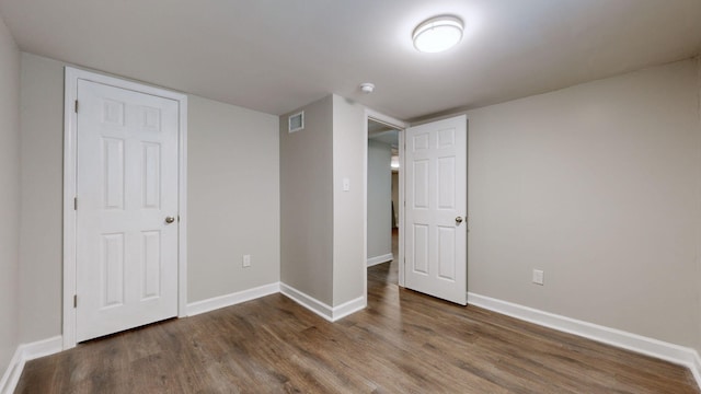 unfurnished bedroom with a closet and dark hardwood / wood-style floors