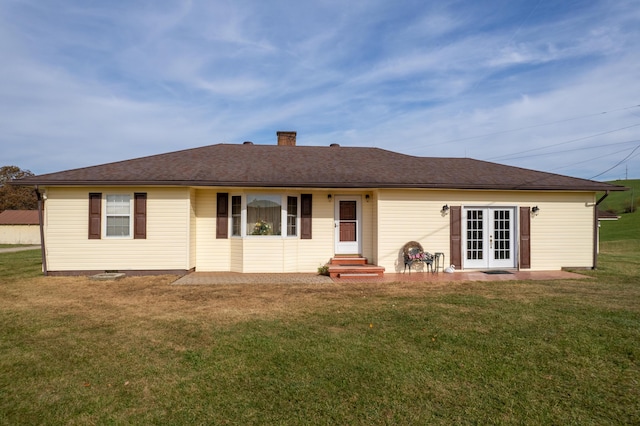 rear view of property with a lawn and french doors