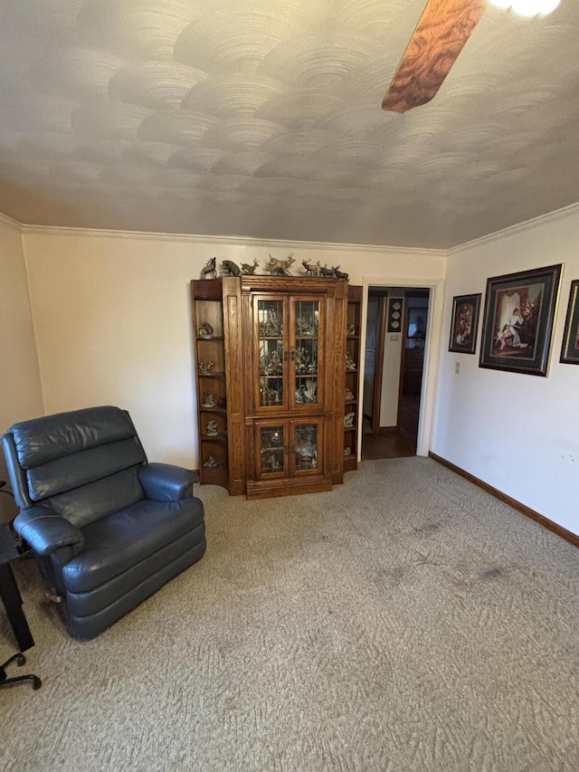 sitting room featuring a textured ceiling, ornamental molding, and carpet floors