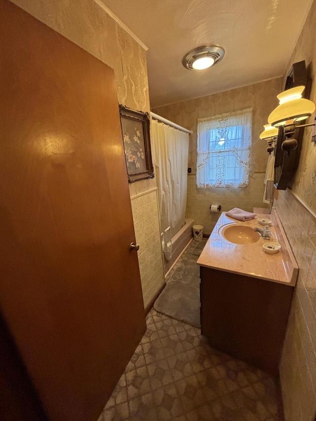 bathroom with vanity, shower / bath combination with curtain, and tile walls