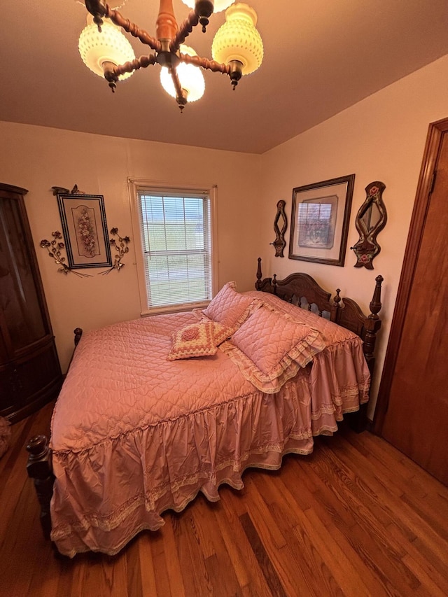 bedroom with hardwood / wood-style floors and ceiling fan with notable chandelier