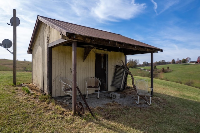 view of outbuilding with a rural view and a yard