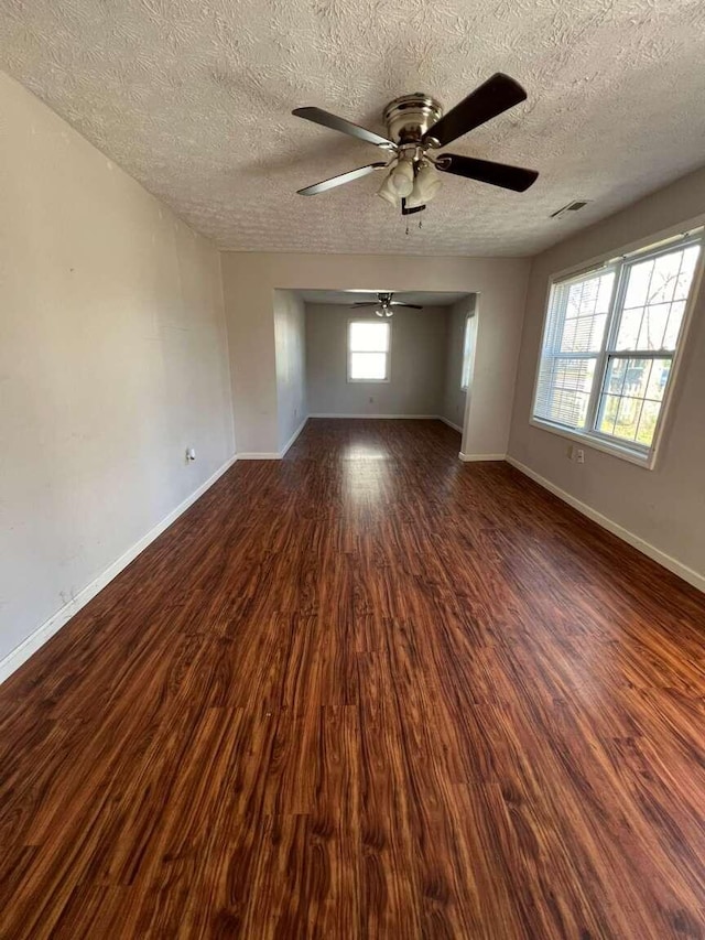 unfurnished room with ceiling fan, dark hardwood / wood-style flooring, and a textured ceiling