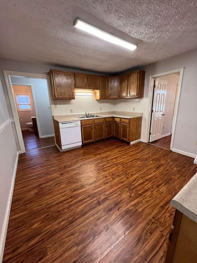 kitchen featuring a textured ceiling, white dishwasher, dark hardwood / wood-style floors, and sink