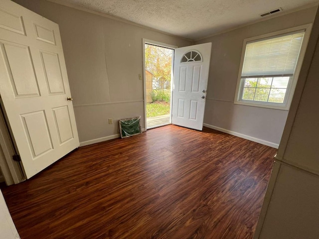 foyer featuring a textured ceiling and dark wood-type flooring