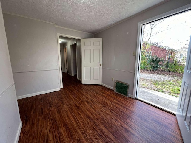 empty room featuring dark wood-type flooring and a textured ceiling