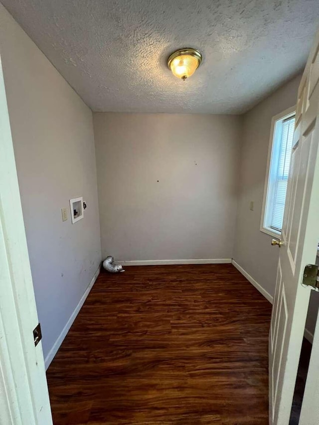 washroom with washer hookup, a textured ceiling, and dark wood-type flooring