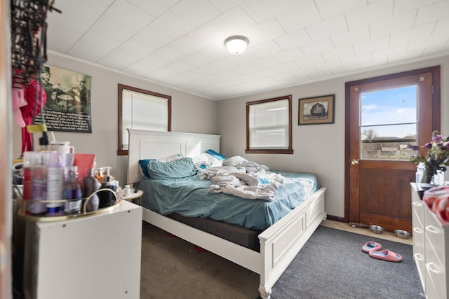 bedroom with dark carpet and crown molding