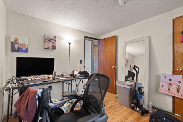 office area featuring light hardwood / wood-style flooring and a textured ceiling