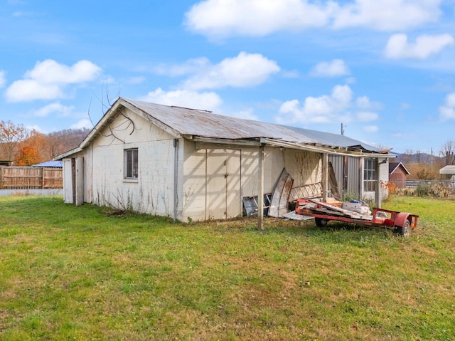 rear view of house with an outdoor structure and a yard