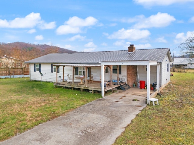 view of front of house with a mountain view, a porch, and a front lawn