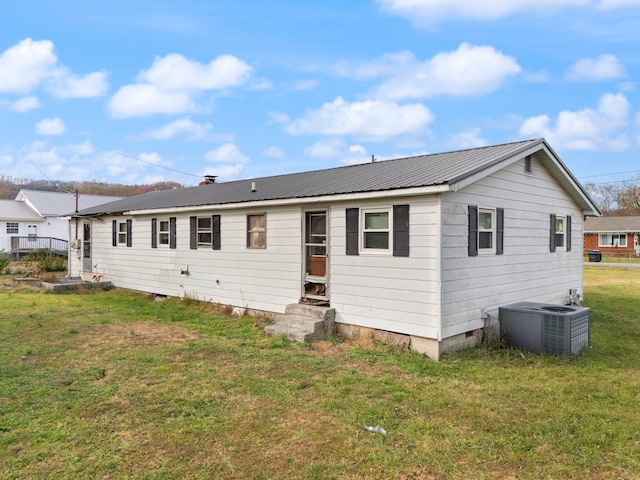 back of house featuring cooling unit and a yard