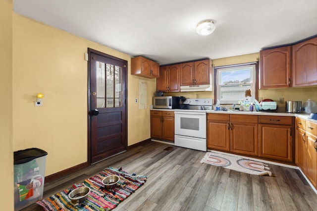 kitchen featuring white range with electric cooktop, wood-type flooring, and sink