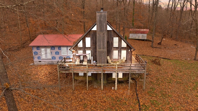 back house at dusk with a wooden deck