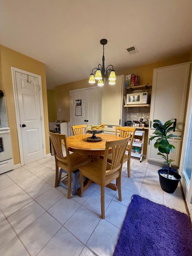 dining area featuring a chandelier and light tile patterned floors