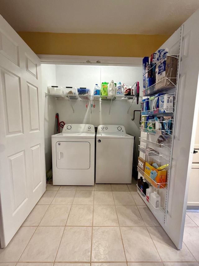 laundry area with washer and dryer and light tile patterned floors