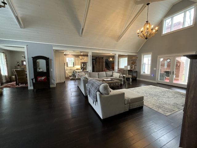 living room with dark hardwood / wood-style flooring, plenty of natural light, and a notable chandelier