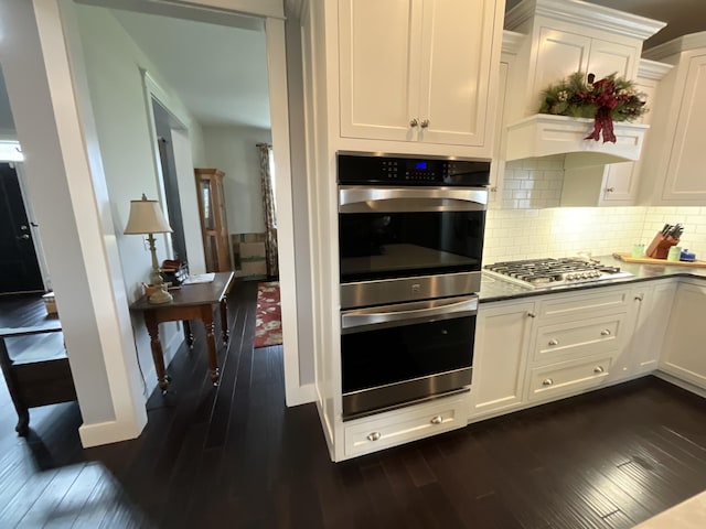 kitchen featuring appliances with stainless steel finishes, dark hardwood / wood-style floors, and white cabinetry