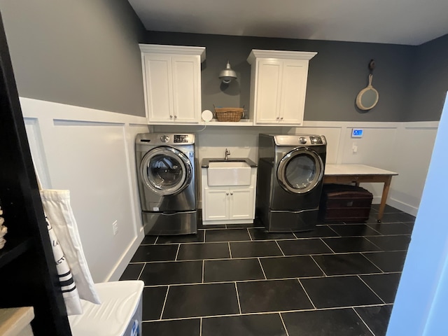 laundry area with dark tile patterned flooring, cabinets, and sink