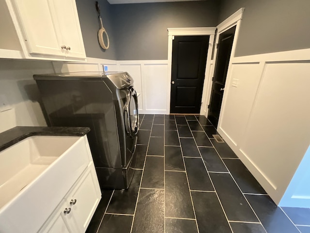 laundry room with washer and clothes dryer, cabinets, and sink