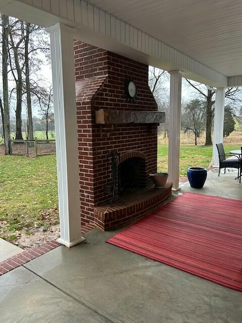 view of patio / terrace with an outdoor brick fireplace and covered porch