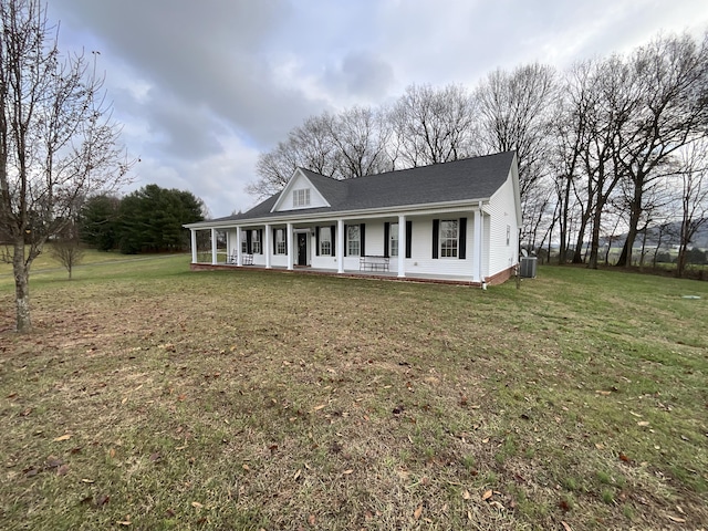 view of front facade featuring central AC, covered porch, and a front lawn