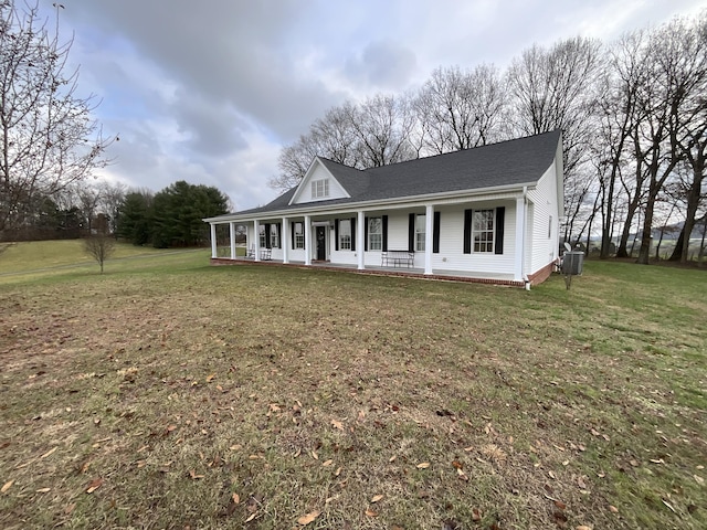 view of front of home with a front lawn, a porch, and cooling unit