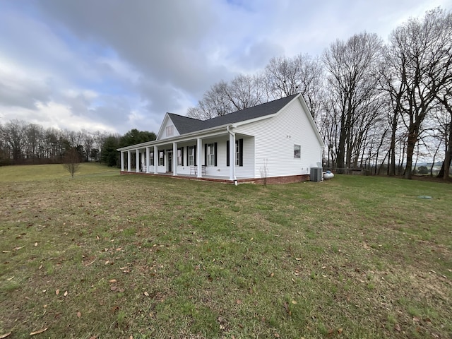 view of property exterior with covered porch, a yard, and cooling unit