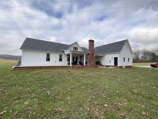 rear view of house featuring a yard