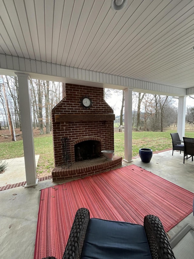 deck featuring a yard, a patio, and an outdoor brick fireplace