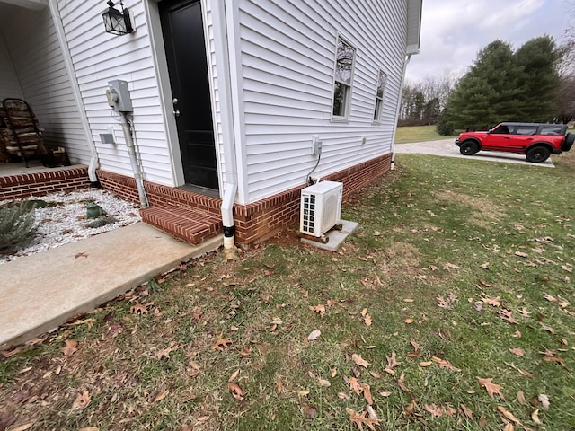 view of side of home with ac unit and a yard