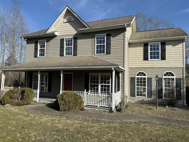 view of front of house with covered porch and a front yard