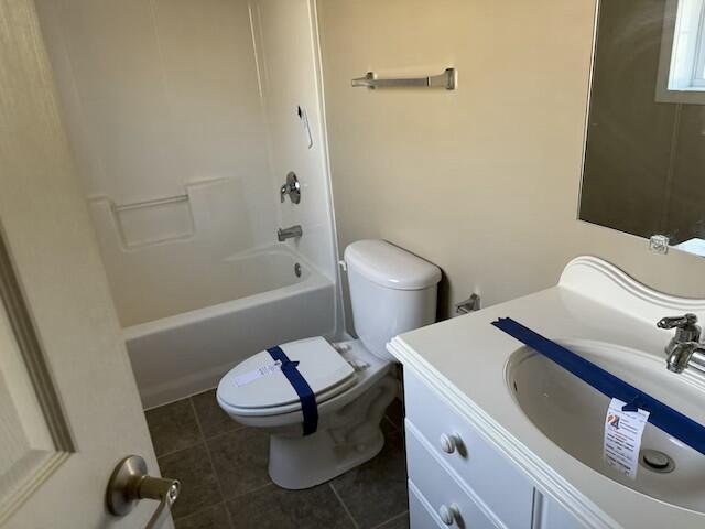 full bathroom featuring tile patterned floors, vanity,  shower combination, and toilet