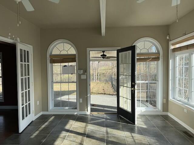 doorway to outside with beam ceiling, ceiling fan, french doors, and dark tile patterned flooring