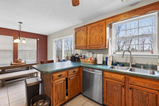 kitchen featuring pendant lighting, sink, stainless steel dishwasher, light tile patterned floors, and kitchen peninsula