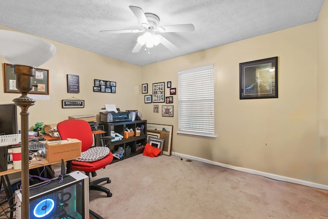 carpeted office space with a textured ceiling and ceiling fan