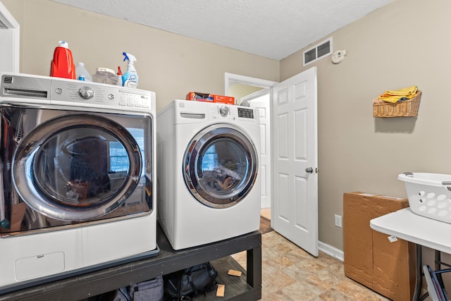 laundry room featuring washer and dryer and a textured ceiling