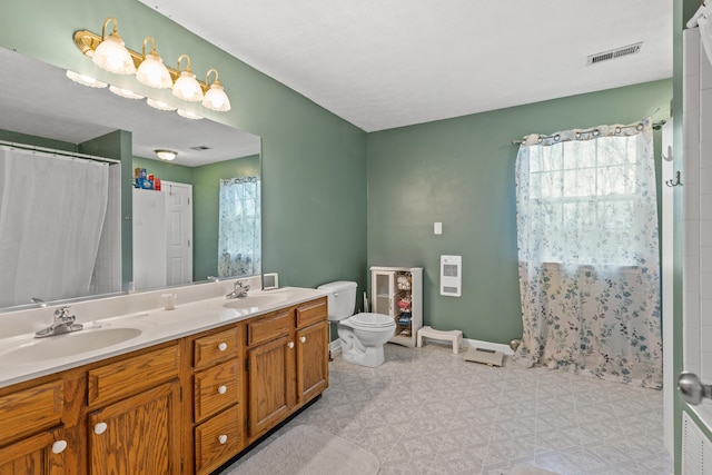 bathroom with vanity, curtained shower, and toilet