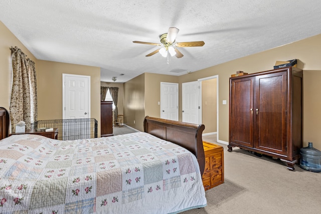 bedroom featuring light carpet, a textured ceiling, and ceiling fan