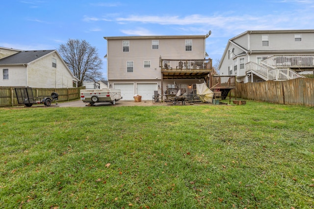 back of house featuring a garage, a deck, and a lawn